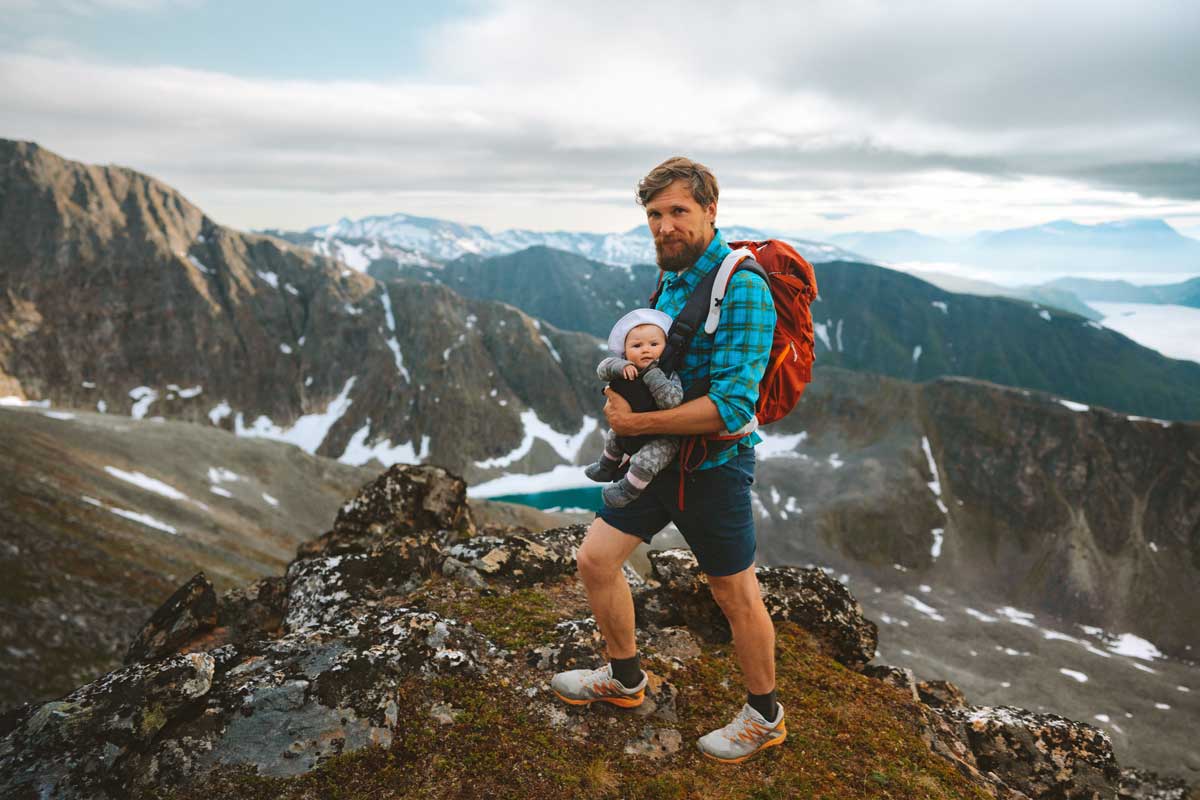 Ein Vater wandert mit seinem Baby in den Bergen.