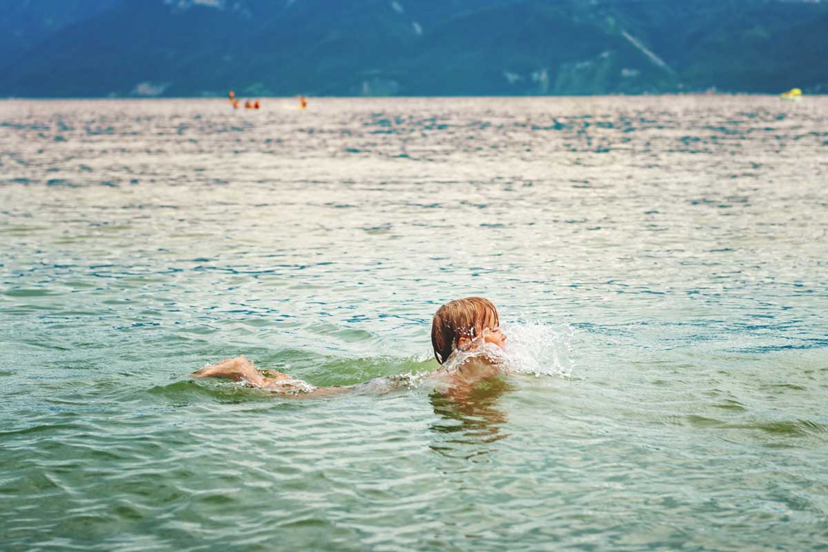 Kind schwimmt in einem Schweizer See