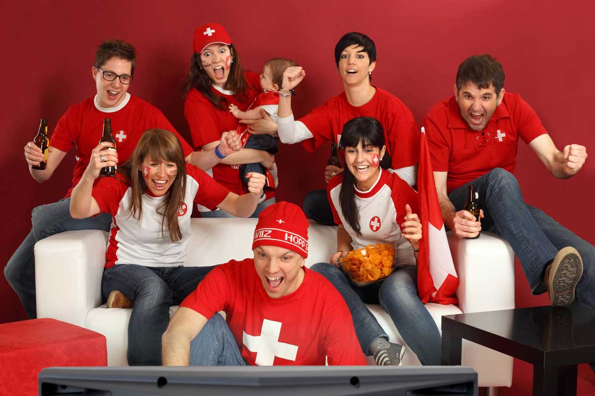 Schweizer Sportfans, die fernsehen und ihr Team anfeuern