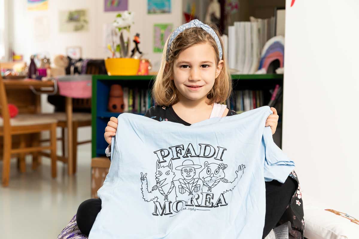 Ein Mädchen zeigt stolz sein Pfadi-Shirt